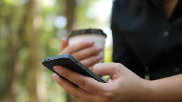 Senhora Usando Telefone Celular Segurando Xícara Café Sobre Fundo Jardim — Vídeo de Stock