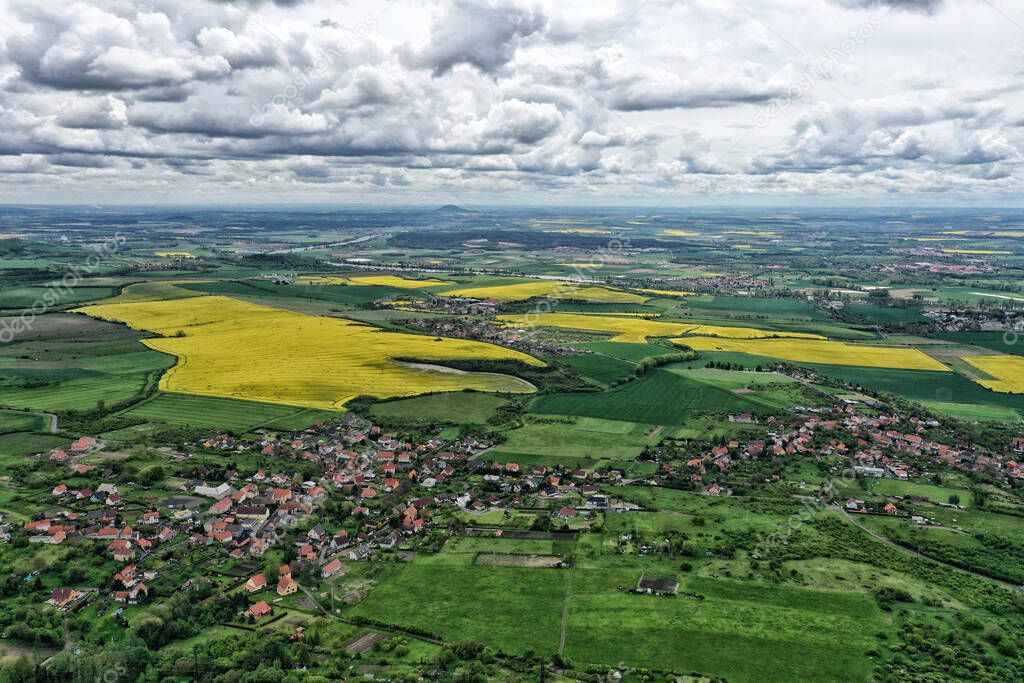 Aerial panorama of Bohemian countryside with yellow rape fields and villages
