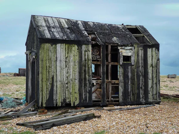 Kent 'teki Dungeness plajında bulunan terk edilmiş balıkçı kulübelerinden biri. Bu, unutulmuş içeriğini havaya maruz bırakarak dağılıyor..
