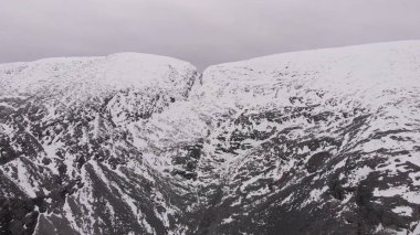 Kuzey Kutbu 'nda karla kaplı uçurum, bulutlu hava, volkanik kaya