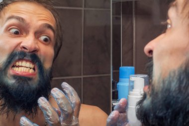 Sakalına mavi boya bulaşmış sakallı bir adam ve yüzünün küçük bir parçası.