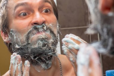 Sakal bakımı - bir adam sakalını sabun köpüğüyle yıkar