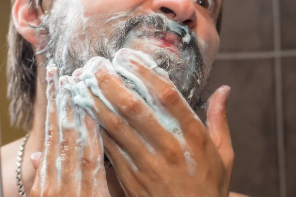 ひげのケア 男は石鹸泡で彼のひげを洗う — ストック写真