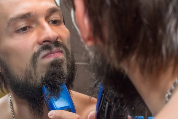 Homem Rapa Barba Com Aparador Eléctrico Perto Espelho — Fotografia de Stock