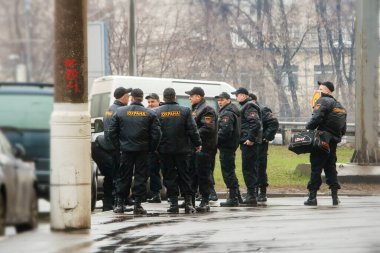   Güvenlik üniformalı bir grup adam birbirine bakar ve iletişim kurar.