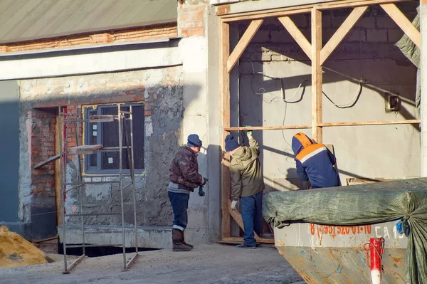 三个工人正在修理一座旧仓库 — 图库照片