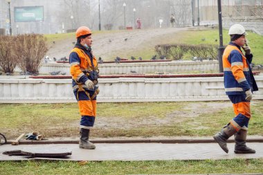Kanalizasyon kapağının yanındaki tesisatçılar.