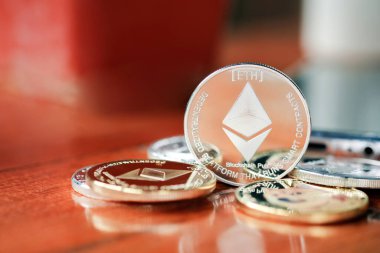 Maesot, Tayland 13 Haziran 2021 'de tahta bir masaya istiflenmiş Ethereum sikkeleri. Şifreleme para sanal para kavramını kabul et.