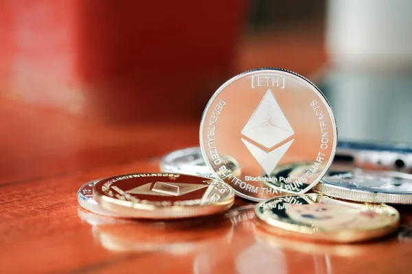 Maesot, Tayland 13 Haziran 2021 'de tahta bir masaya istiflenmiş Ethereum sikkeleri. Şifreleme para sanal para kavramını kabul et.