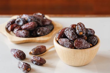 Medjool masanın üzerindeki tahta bir kabın içinde duruyor. En büyük boyutta tarihlerin kralıdır..