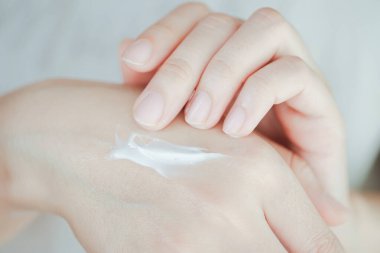 Cilde nem eklemek için kadının elindeki cilt kremi. Elin sağlık hizmeti kavramı.