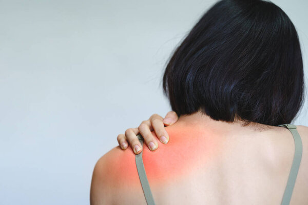 A woman has pain in her shoulder blades because she sits at work for too long.