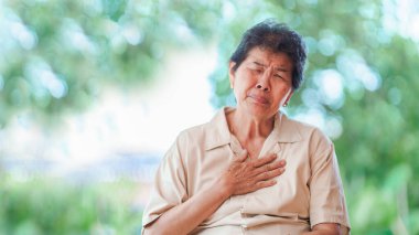 Yaşlı kadının göğüs ağrısı var. Çünkü kalp rahatsızlığı var. Yaşlılarda sağlık sorunları kavramı.