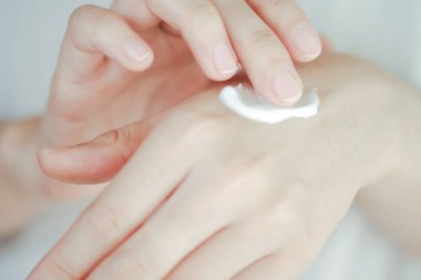 Kadın elleri krem sürüyor. Cilt bakımı kavramı.