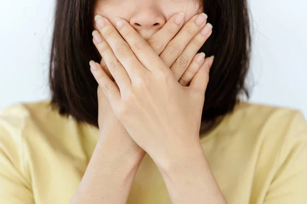 The woman covered her mouth with her hand.