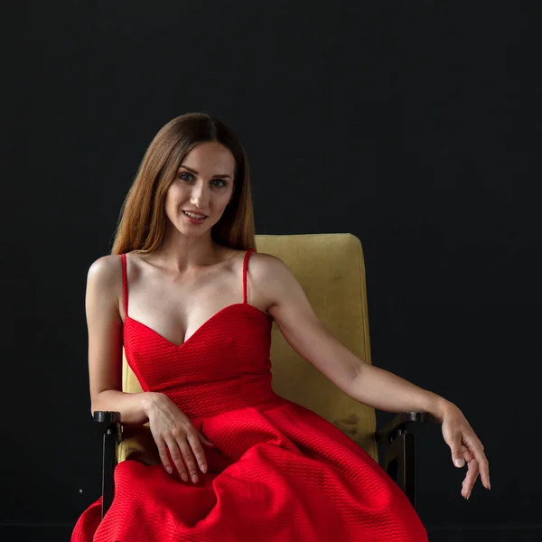 Retrato Bela Jovem Mulher Sentada Cadeira Vestido Vermelho Fundo Escuro — Fotografia de Stock