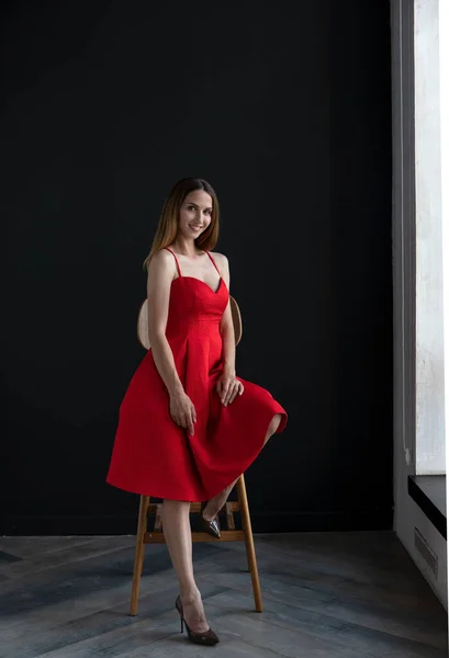 Retrato Bela Jovem Mulher Sentada Cadeira Vestido Vermelho Fundo Escuro — Fotografia de Stock