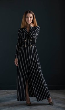 portrait of beautiful young woman in black dress on dark background