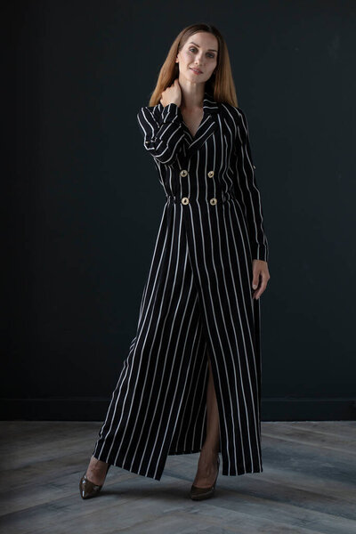 portrait of beautiful young woman in black dress on dark background