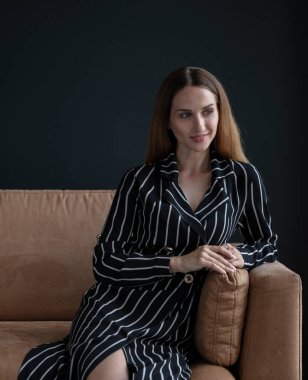 beautiful woman posing in studio wearing striped dress 