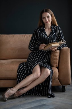 beautiful woman posing in studio wearing striped dress 