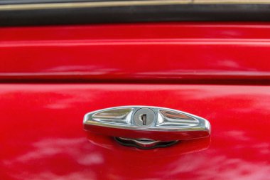 Klasik kırmızı bir arabanın arka kapağını açmak için kapı kolunu kapat.