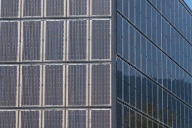 Güneş enerjisinin bağımsız üretimi için fotovoltaik panellerle kaplı bina cephesi
