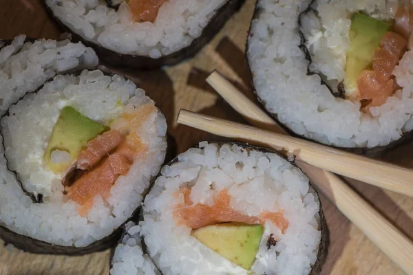 Zblízka Dřevěný Talíř Několika Sushi Rolky Rýžovou Okurkou Lososem Vedle — Stock fotografie