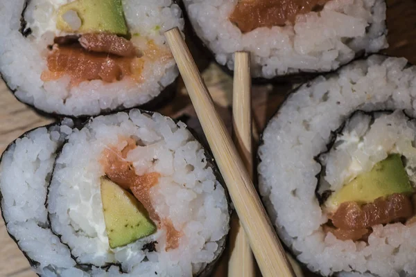 Zamknij Cztery Bułki Sushi Ogórkiem Ryżowym Łososiem Obok Pałeczek — Zdjęcie stockowe