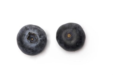 Farklı taraflardan görülen iki koyu mavi yaban mersini beyaz arka planda izole edilmiş.