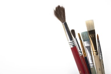 Beyaz arka planda izole edilmiş resim ve sanat konsepti olarak birkaç farklı fırça ve saç fırçasını kapat