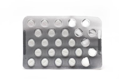 Closeup of silver blister with small white film tablets as tablets in package medicine on white background