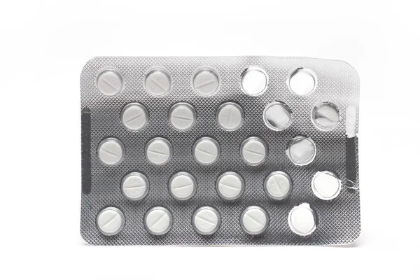Closeup of silver blister with small white film tablets as tablets in package medicine on white background