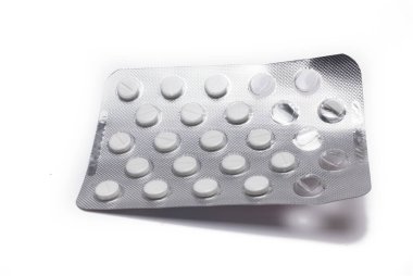 Close up of silver blister with small white film tablets on white background tablets in package medicine