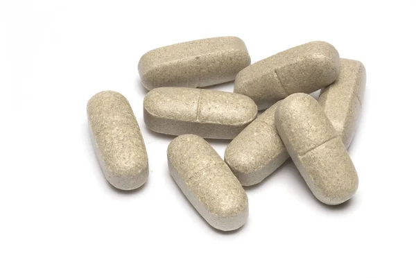 Close up of several large tablets as food supplement vitamin preparation on white background