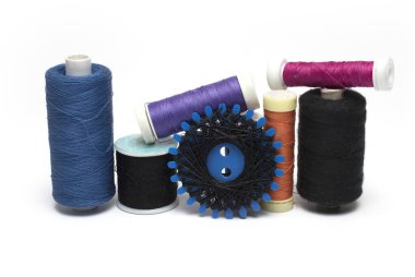 Close up of different rolls and blisters of sewing thread and thread on white background