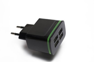 Beyaz arka planda şarj edilen cep telefonu için dört USB portu olan siyah AB buji adaptörünü kapat
