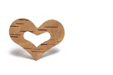 Güzel, kahverengi, tahta bir kalbe yakın, huş ağacından kesilmiş gölgesi ve beyaz arka planda kalp şeklinde bir merkezi var.