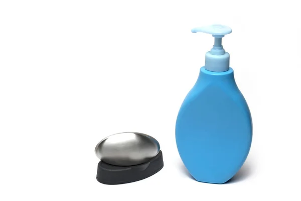 白い背景にステンレス製の石鹸のバーの横にクリーム又は石鹸の衛生的な分割のための薄い青色のディスペンサーの閉じる — ストック写真