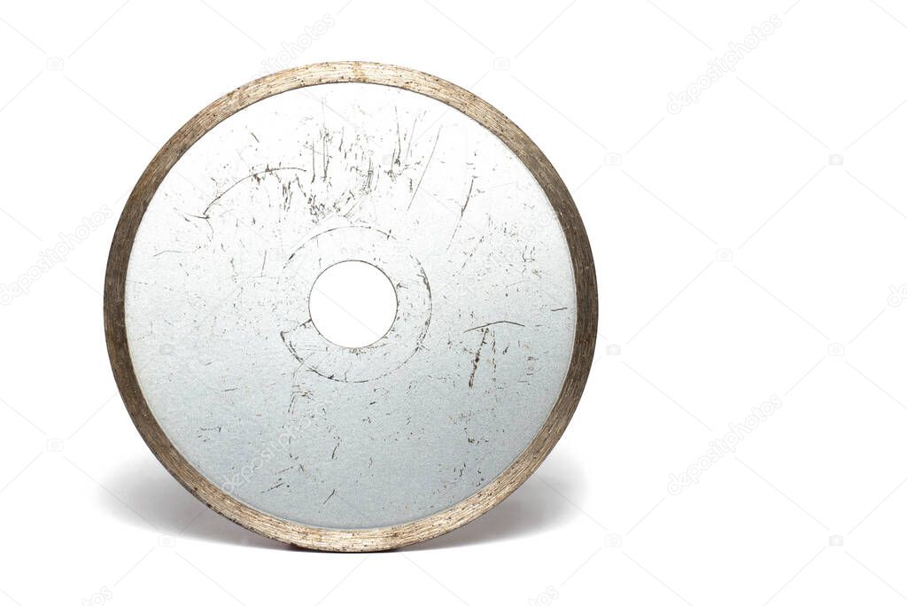 heavily used metal silver shiny special carbide cutting disc close up for cutting stone slabs and tiles when laying tiles for use in angle grinder on white background