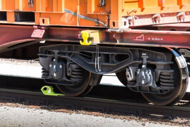 Demiryollarında güneşli bir günde, düşük katlı konteynır vagonunun tamponlarıyla kargo taşımacılığı ve taşımacılığı konsepti olarak ön tarafı kısmen kapatın.