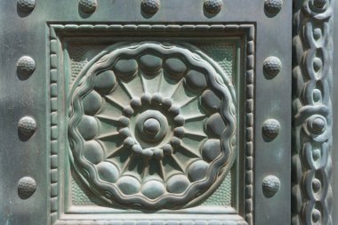 Close-up of an old historic copper ornament pattern with a round rosette and green patina