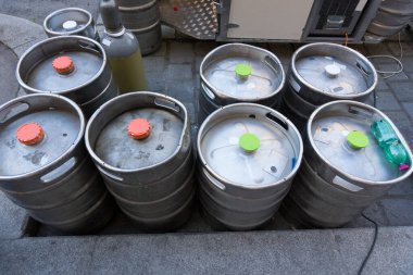 Açık hava etkinlikleri ve sokak partisi konsepti olarak açık hava satış tezgahlarının önünde bira fıçıları var.