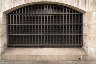 Close up of window heavily barred with solid metal steel iron lattice in historic old building as concept for prison imprisonment and burglary protection