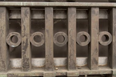 Partial close view of steel iron wrought iron fence with forged bars and rings for use as a background and as a concept artistic handcrafts