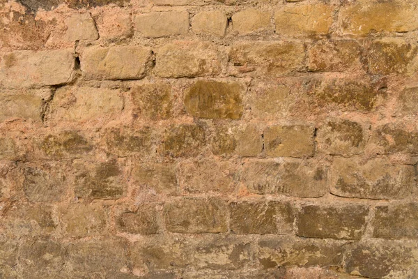 Close up sandstone beige brown colored exactly bricked laid brick stone wall l perfectly aid to be used as background and concept old buildings brick walls