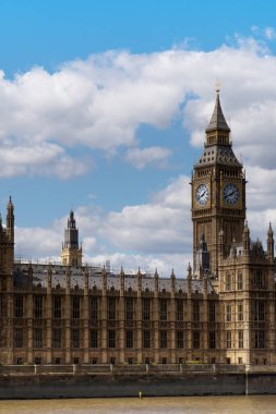 Londra 'daki Big Ben kulesiyle İngiliz Parlamentosu' nu kapatalım. Parçalı bulutlu gökyüzüne karşı ünlü bir manzara olarak.