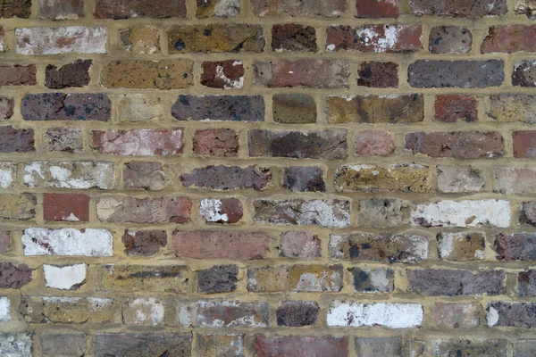 Close up stone wall several colored bricks exactly laid bricked laid brick as background and concept for bricks buildings and build old buildings walls