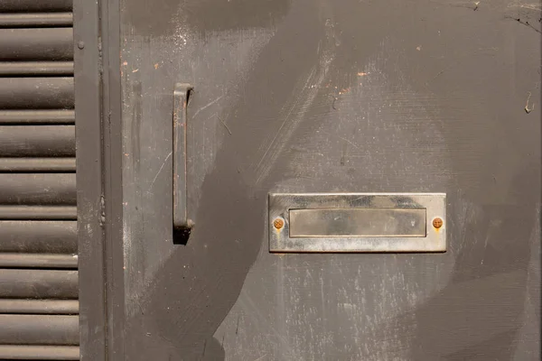 郵便物のコンセプトとして鉄光沢のある銀メールスロットと錆びた入り口スチールドアの閉鎖 — ストック写真