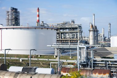 Fosil yakıtları yenilenemez enerji konsepti olarak yüklemek için depolama tankları ve demiryolu tankerleriyle modern endüstriyel petrol rafinerisinin kısmi görüntüsü